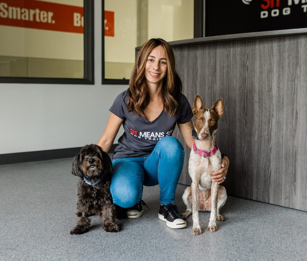 trainer sitting with two dogs